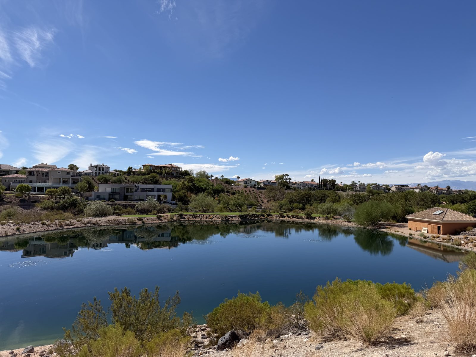 A lake in Anthem, Henderson, with custom hillside homes on the ridge behind it
