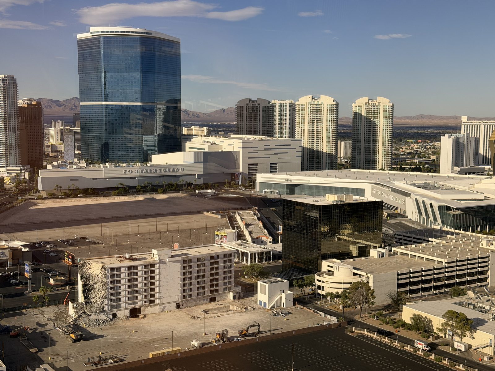 Residential high-rise towers clustered behind the Fontainebleau tower and the Las Vegas Convention Center, seen from above