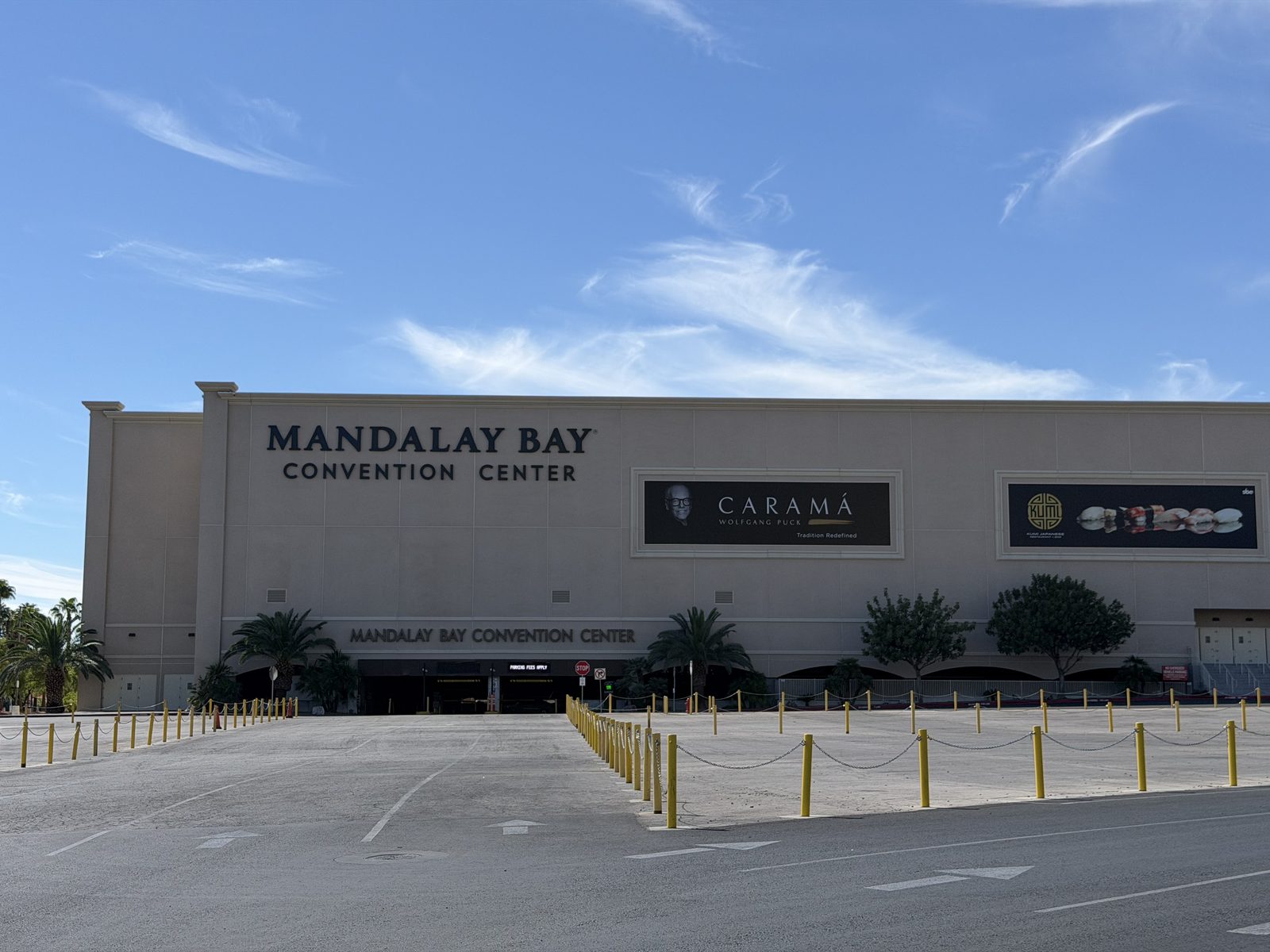 The Mandalay Bay Convention Center entrance on the south Strip, with its signage above the doors and the arrival drive in front