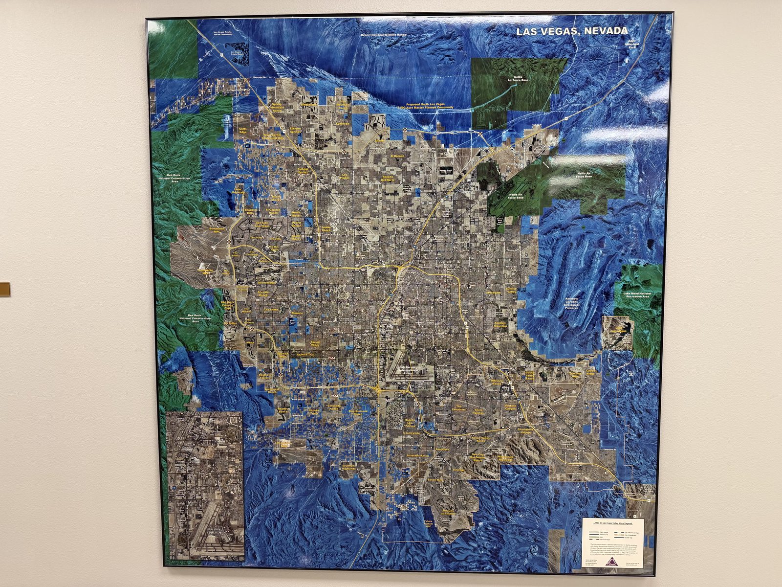 A large relief map of the Las Vegas valley on the office wall showing the developed floor ringed by mountains