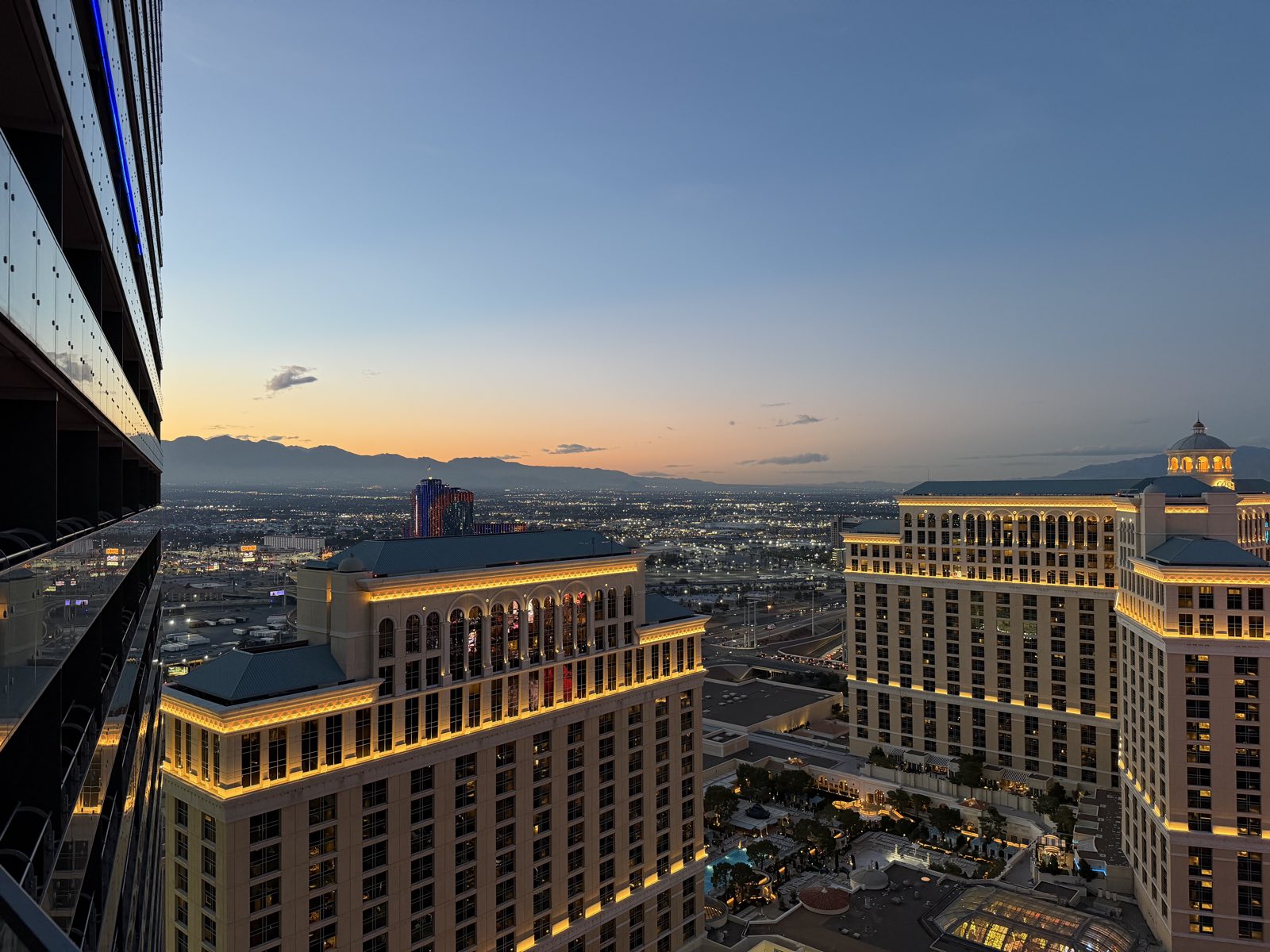The Las Vegas Strip at sunset with the Bellagio lake in the foreground and the mountains behind the resort towers