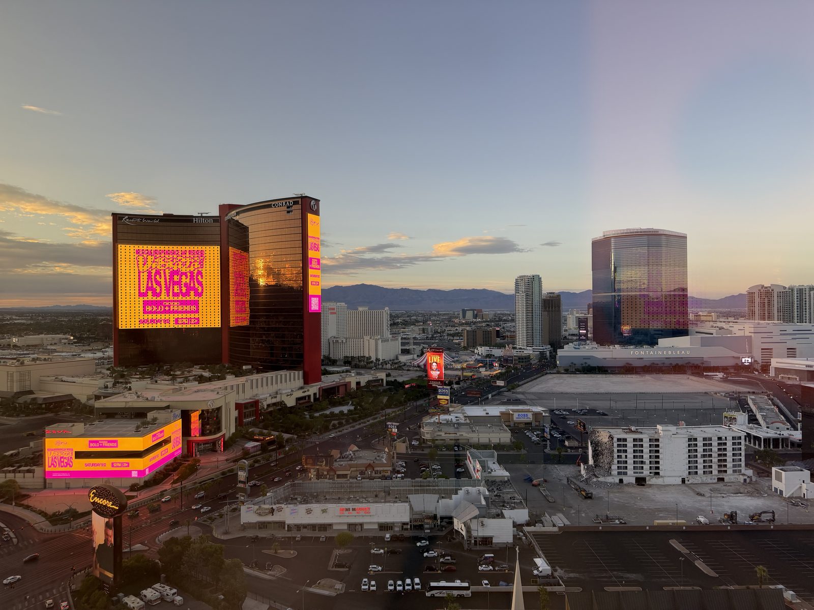 The north Strip at golden hour with Resorts World lit up and the Fontainebleau tower catching the last light